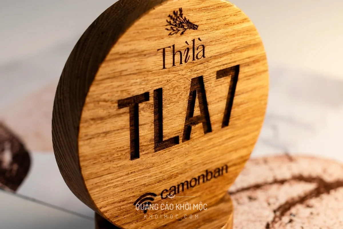 Thẻ gỗ tròn khắc logo nhìn nghiêng 45 độ, thấy độ dày mặt gỗ