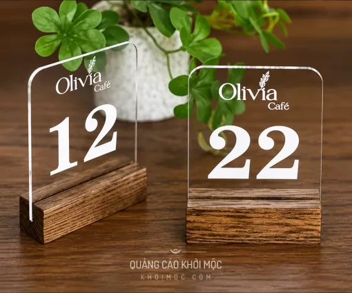 Hai thẻ số bàn mica trong suốt Olivia Café, số 12 và 22, cắm trên đế gỗ